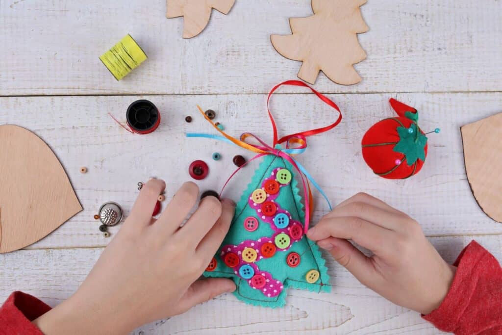 A child is making a christmas tree ornament.