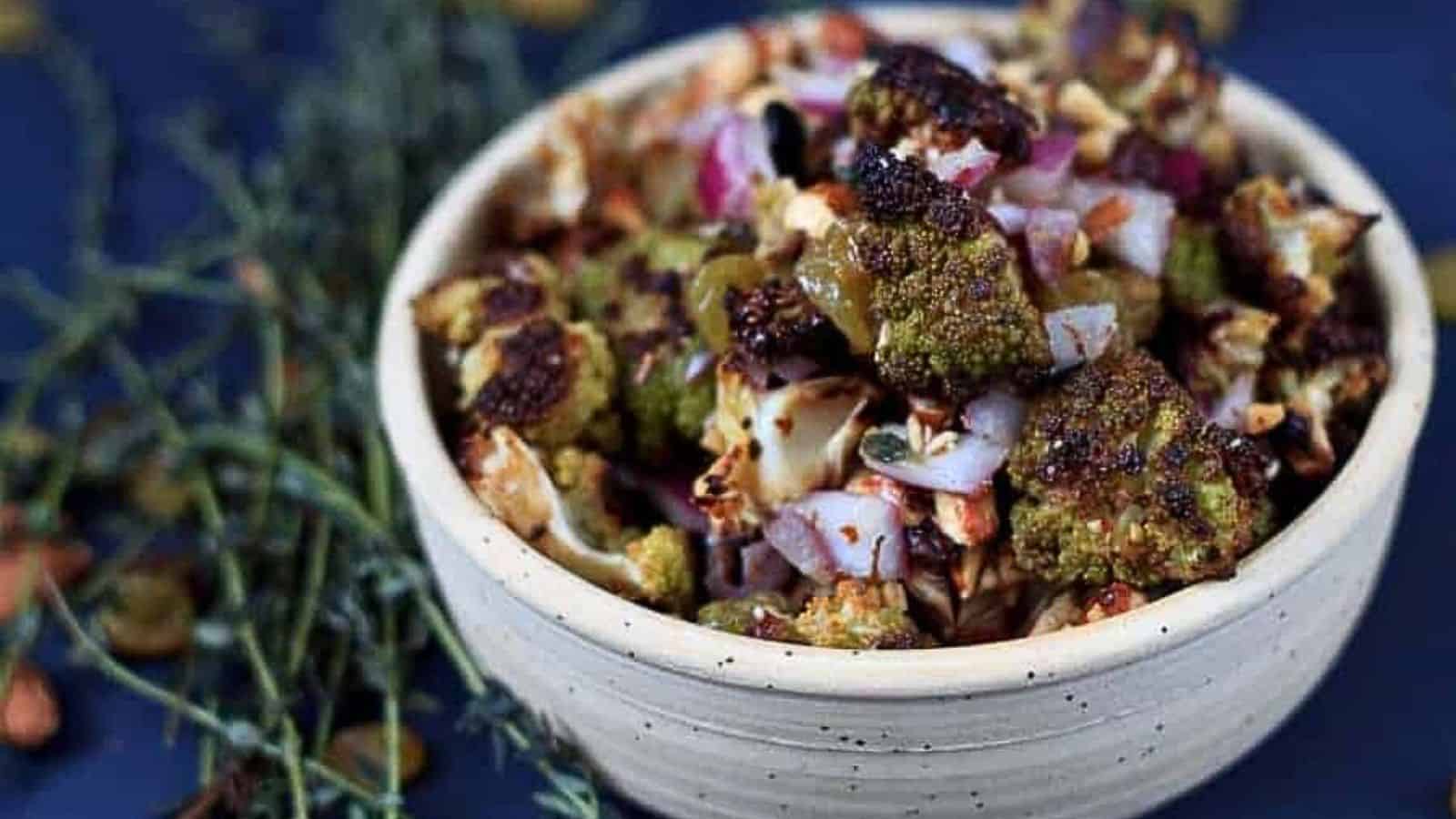A bowl of roasted cauliflower with onions and sprigs of thyme.