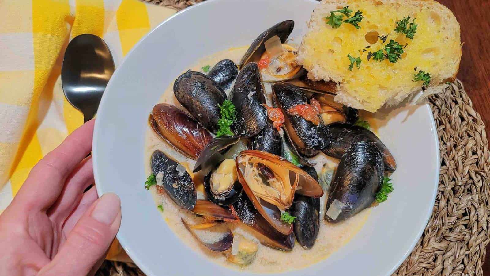 A bowl of steamed mussels in jalapeno cream sauce ready to eat.