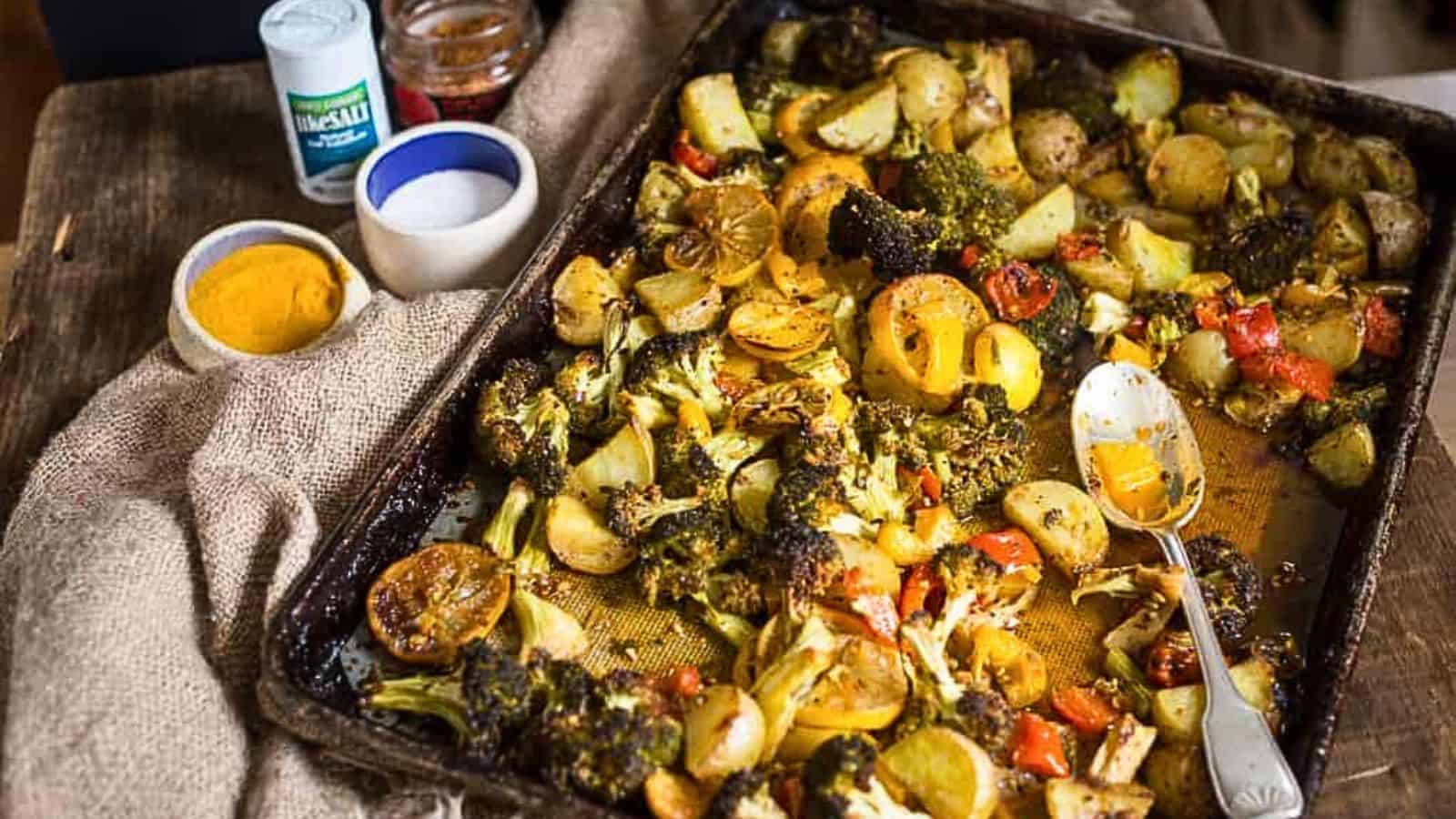 A baking pan full of vegetables and a spoon.