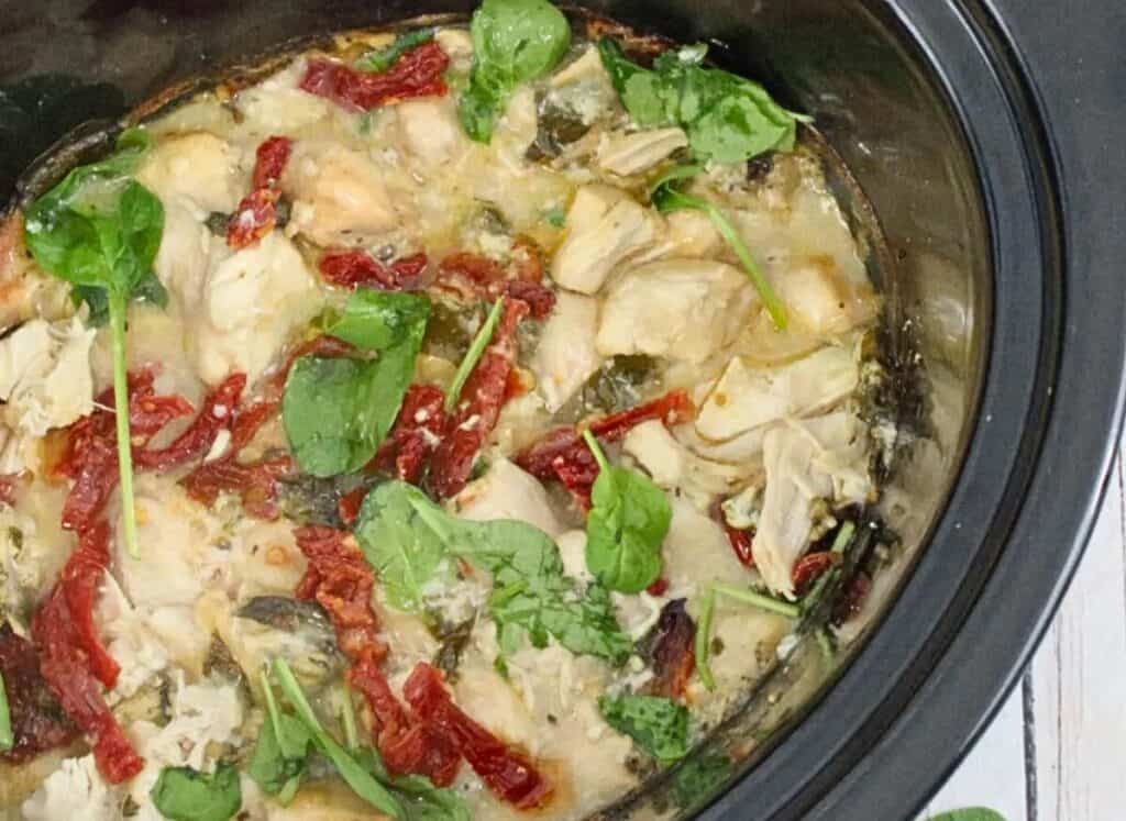 A crock pot full of chicken and vegetables.