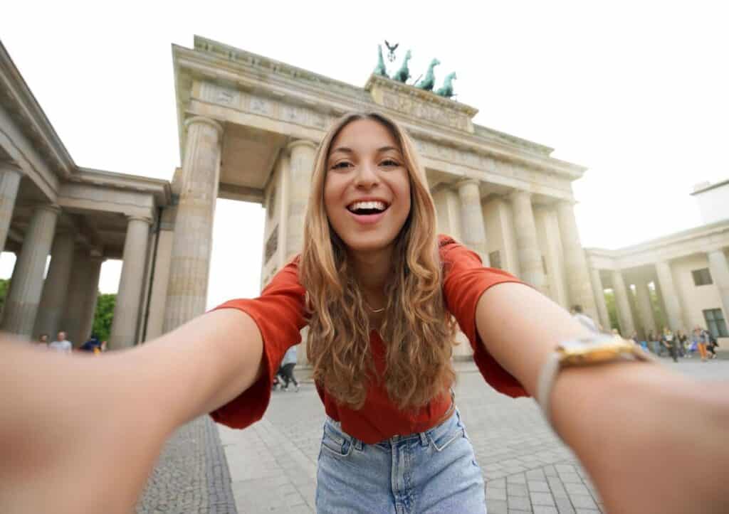 A woman is participating in a scavenger hunt at the Brandenburg Gate in Berlin.