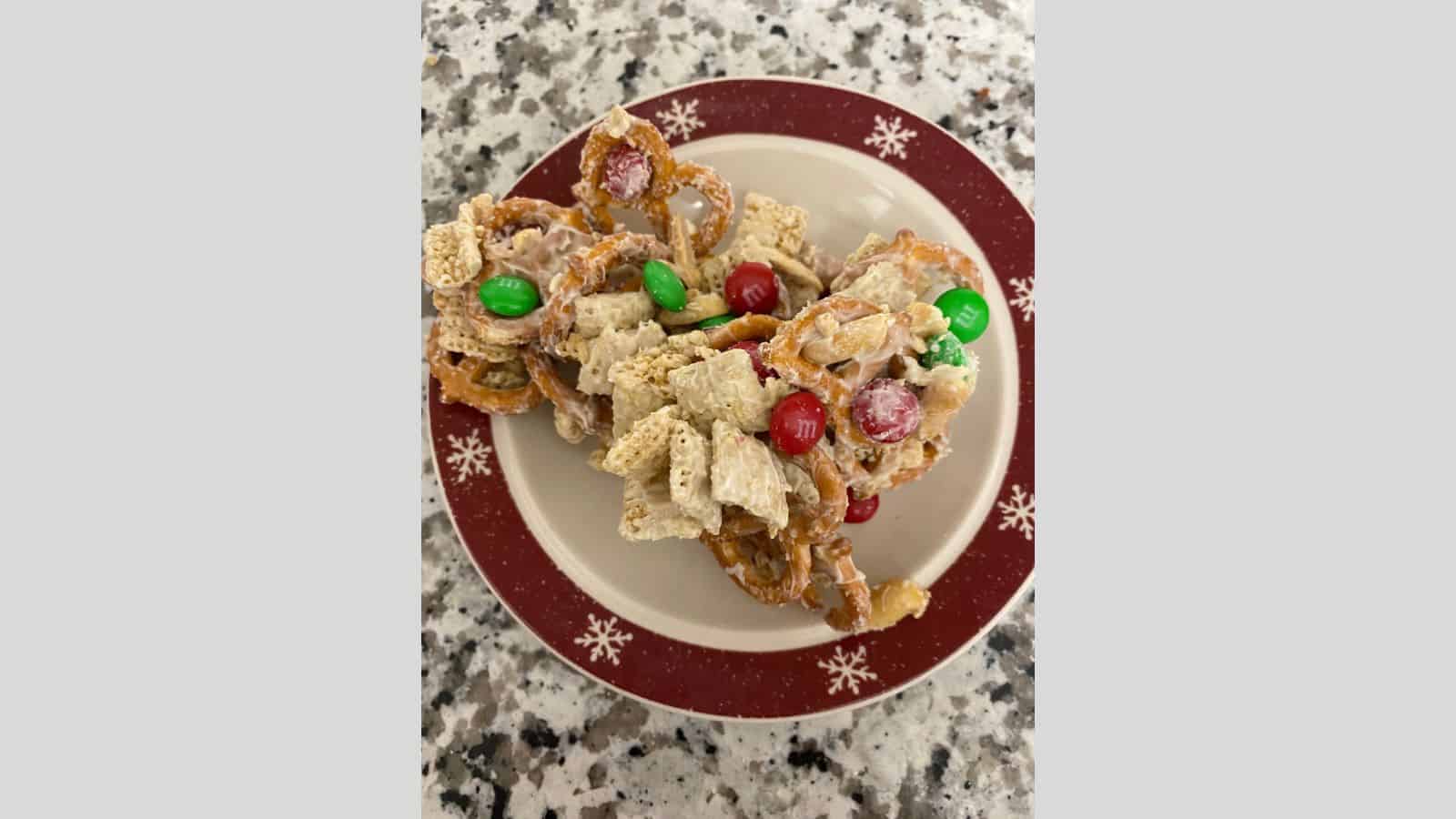 A plate topped with white chocolate covered cereal and m&m's.