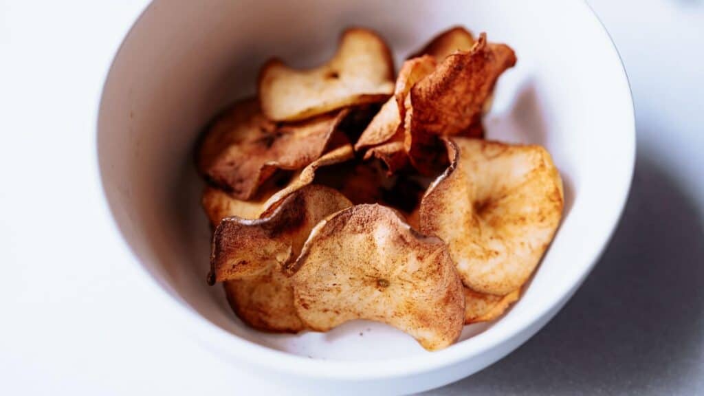Apple chips in a bowl on a table.