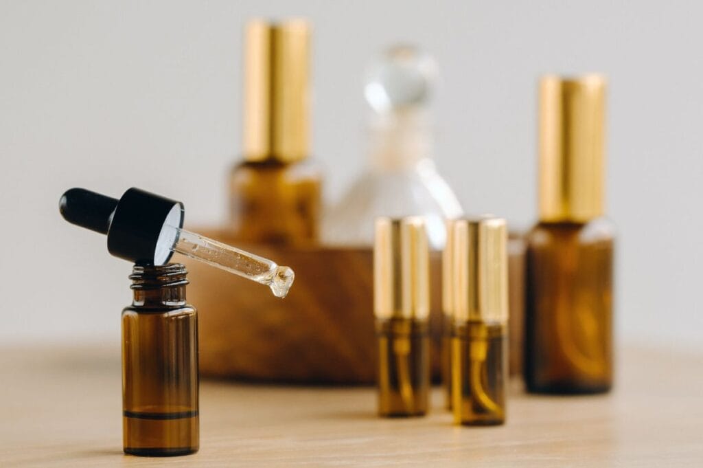 A bottle of essential oil with a dropper on a wooden table.