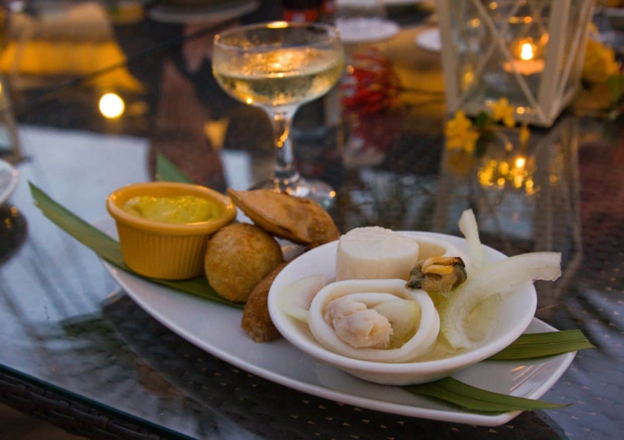 A plate of food on a table next to a glass of wine.