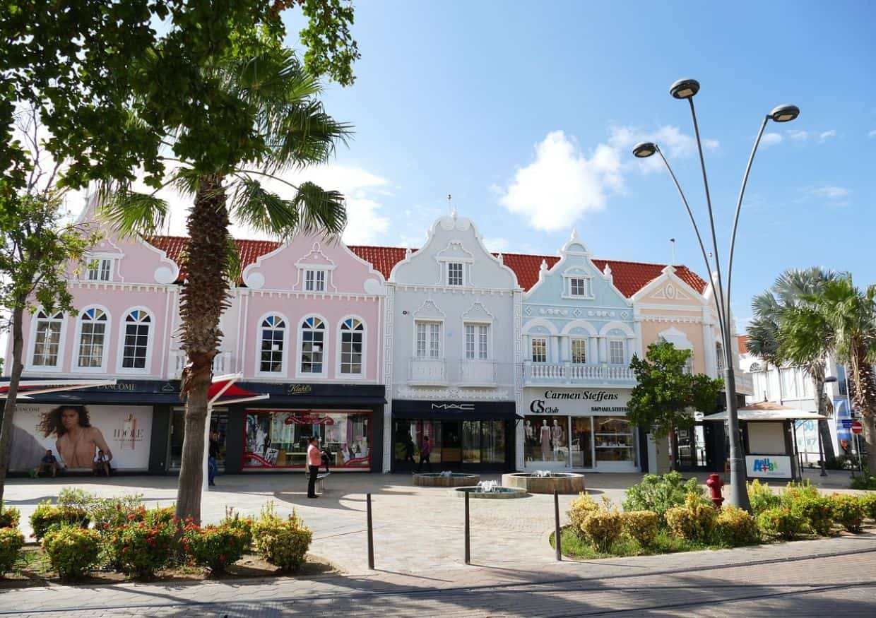 A street with many buildings and palm trees.