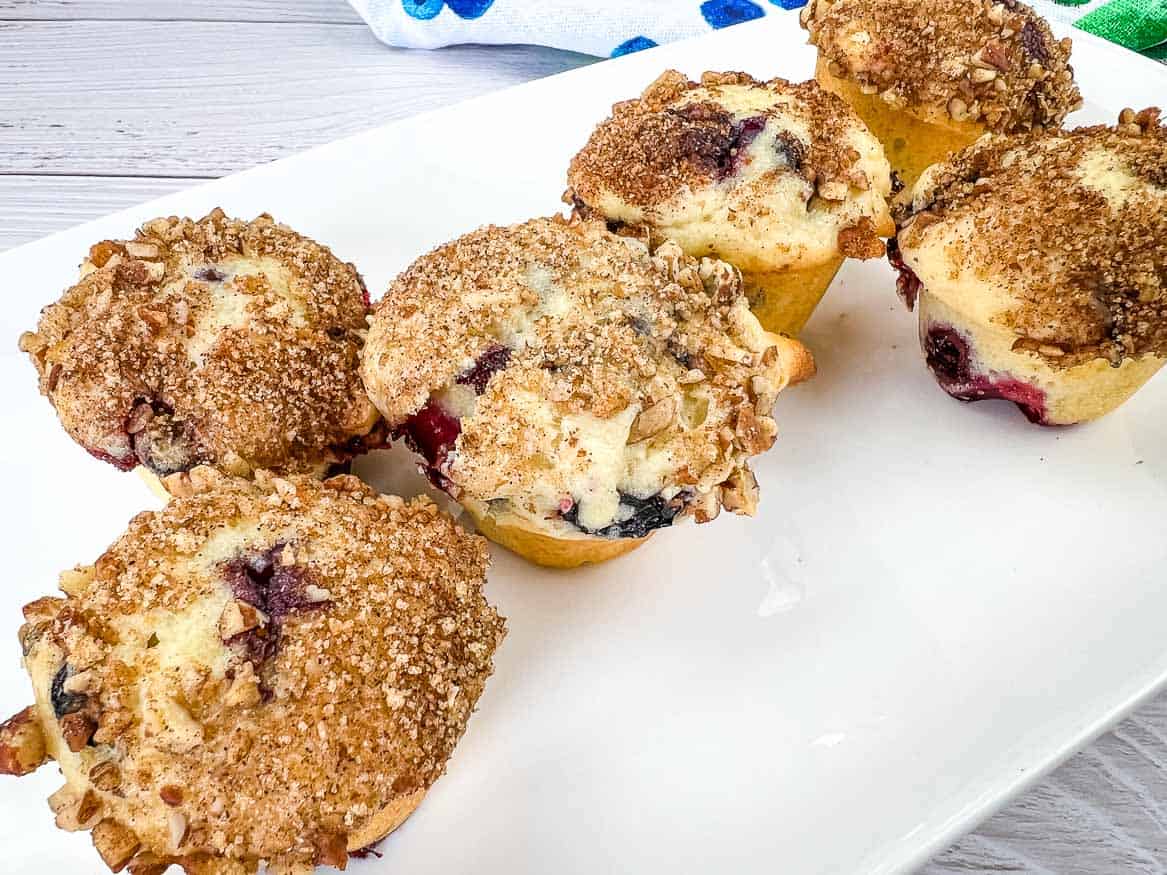 Blueberry crumb muffins on a white plate.