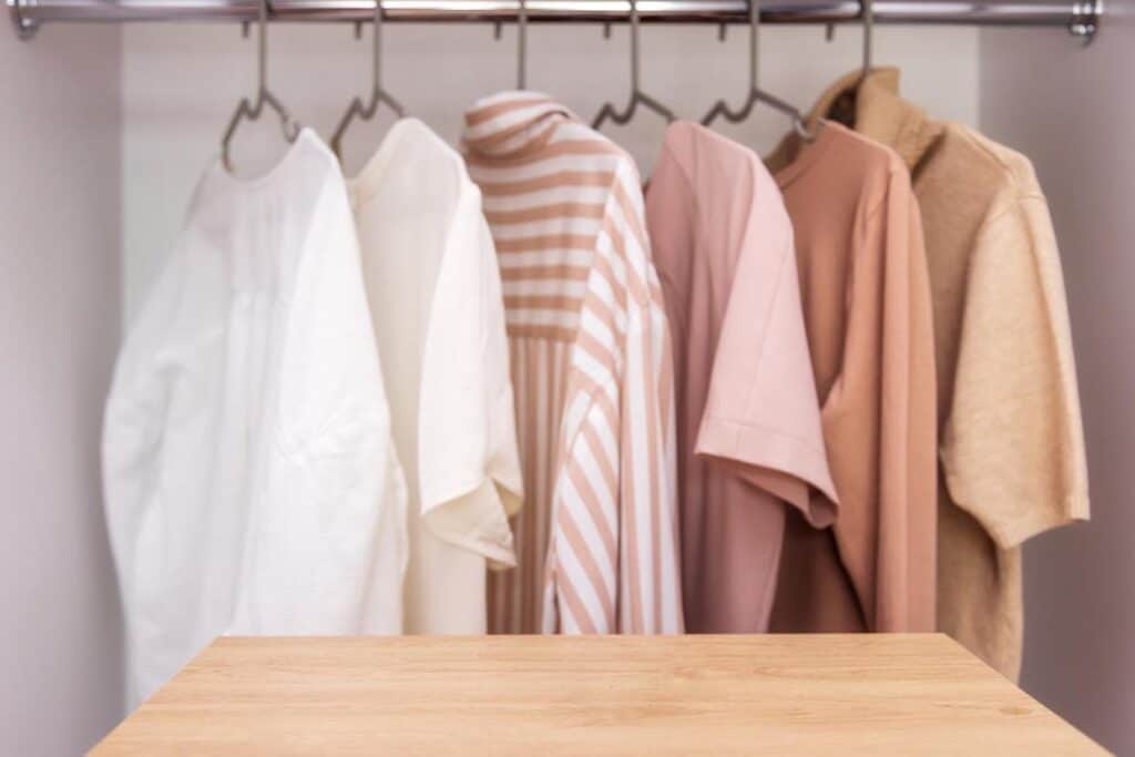 Capsule wardrobe featuring clothes hanging on a rack in a closet.