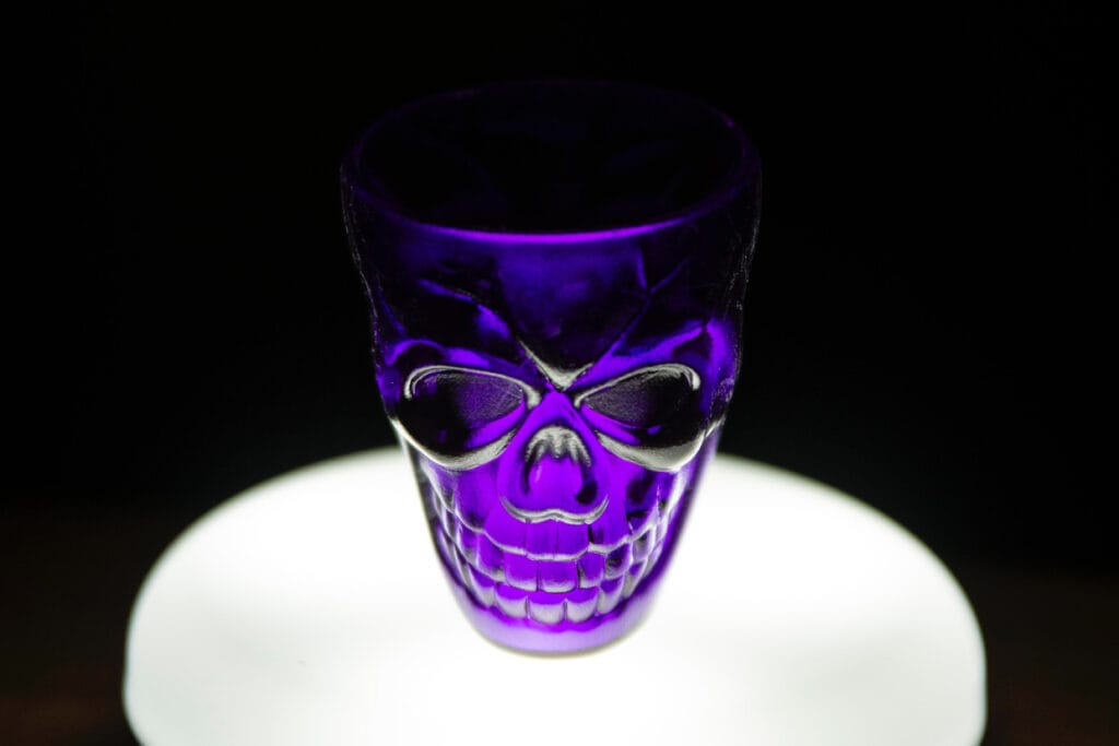 A purple glass with a skull on it.