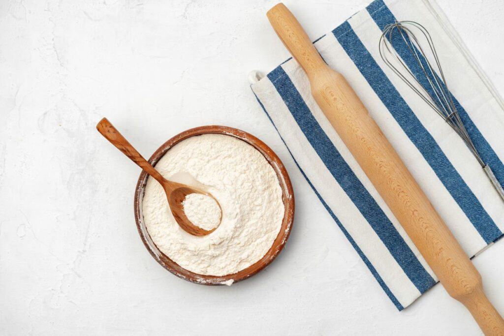 A bowl of flour and a rolling pin.