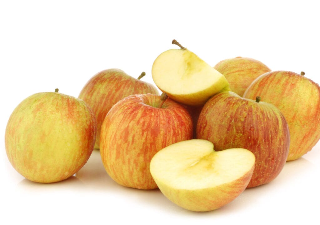 A pile of Fuji apples on a white background.