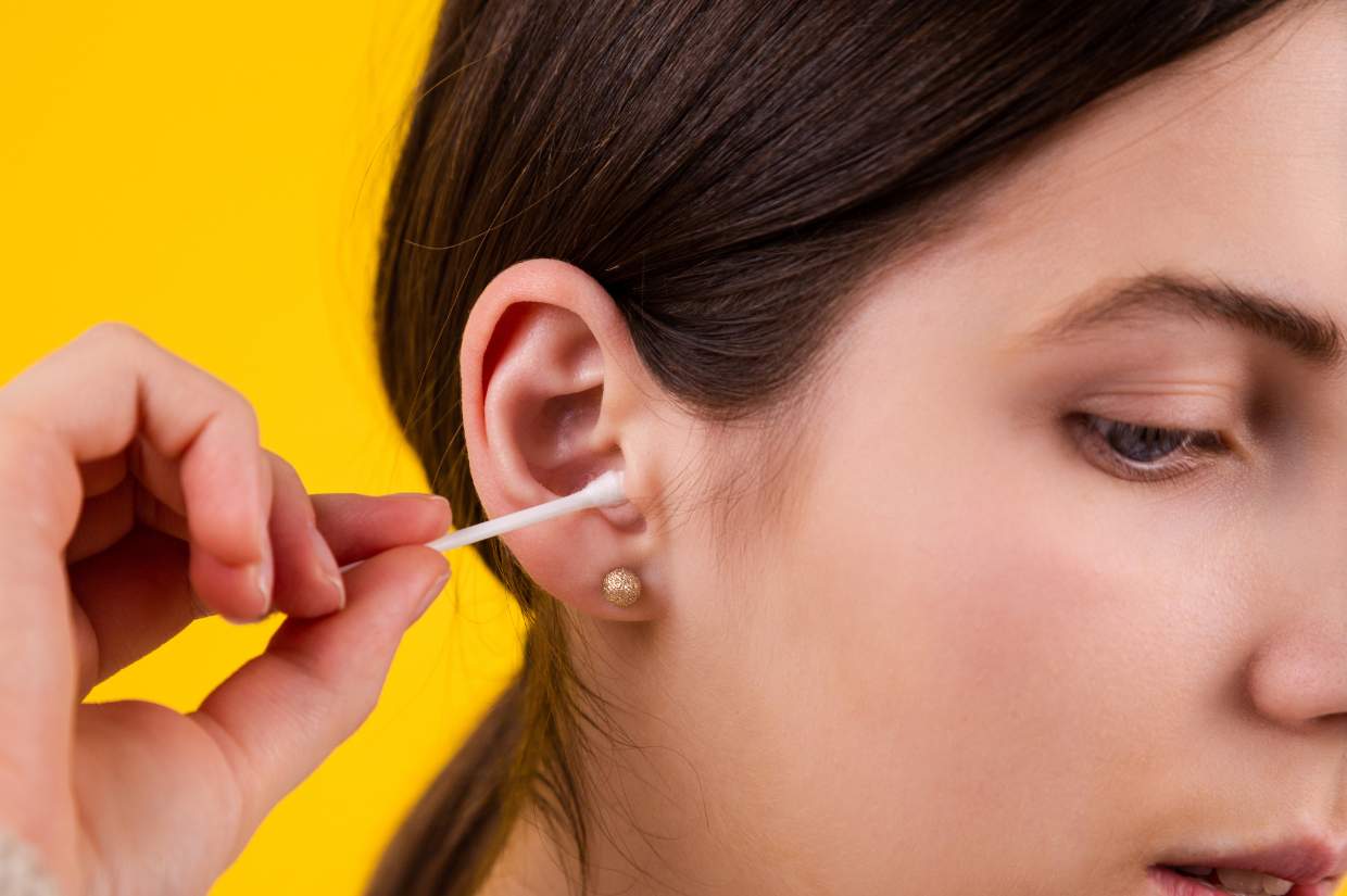 A woman is getting an ear piercing.