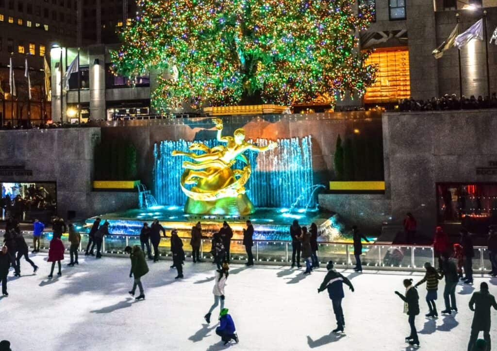 Rockefeller Center Christmas tree surrounded by ice skaters.