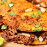 A meaty taco on a wooden cutting board.