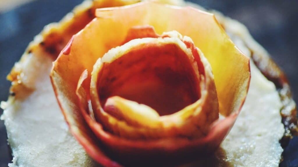 A close up of a flower on a piece of tart.