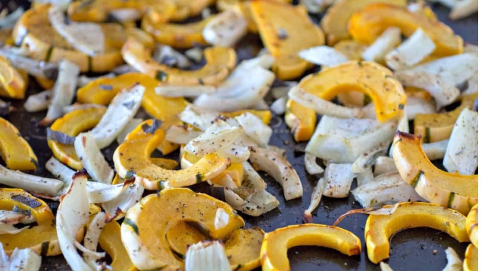 Roasted squash and onions on a baking sheet.