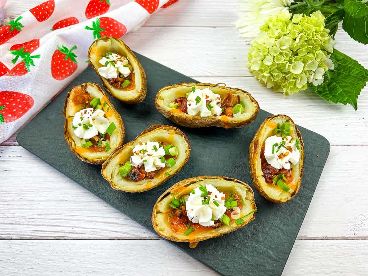 Four potato skins topped with cheese and sour cream.