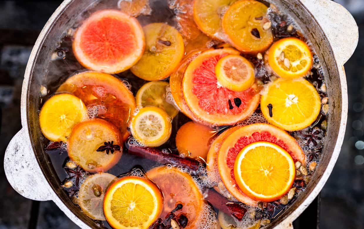 A pan filled with oranges and spices on an outdoor grill.