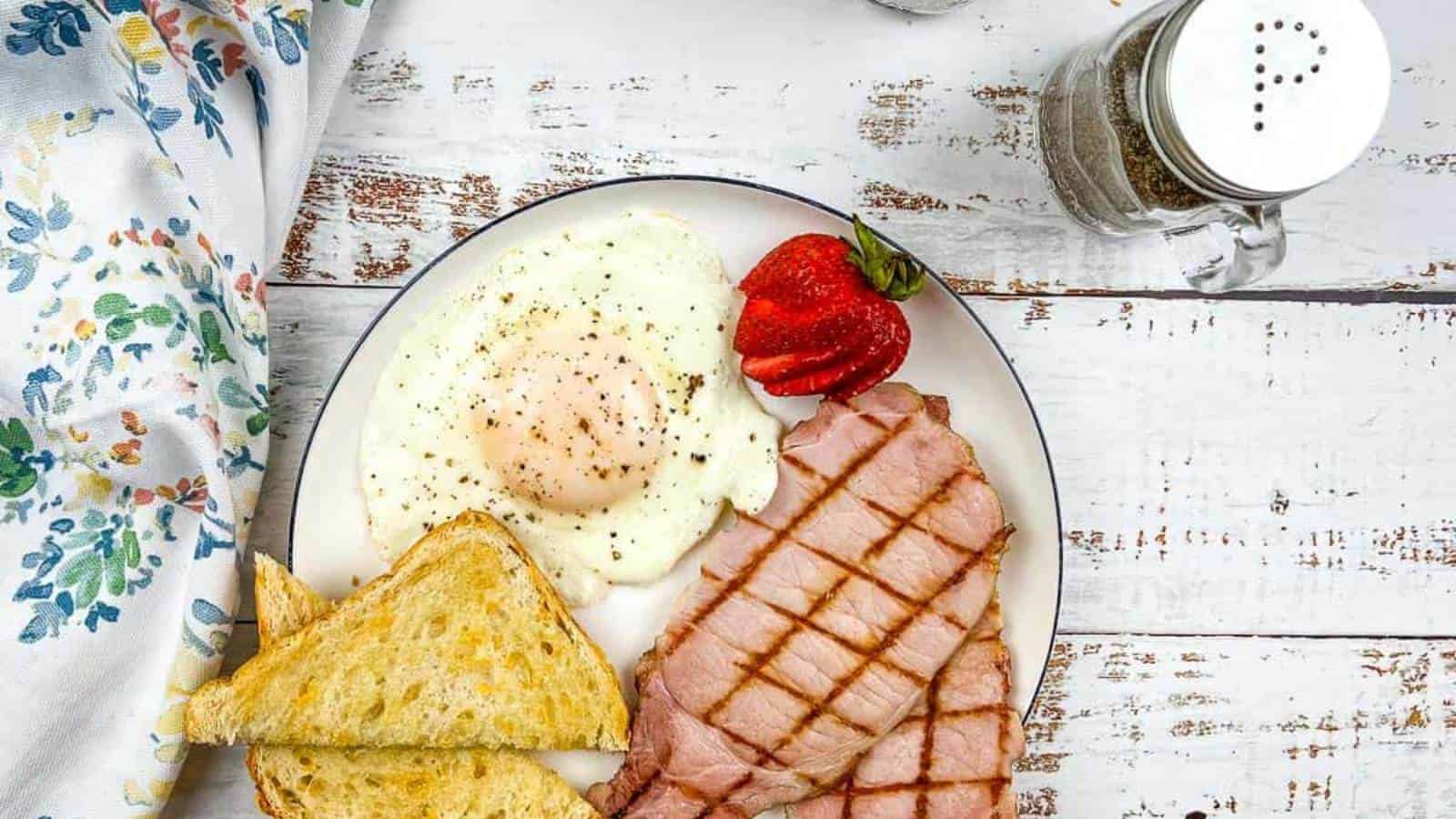 A plate with back bacon, eggs and toast.