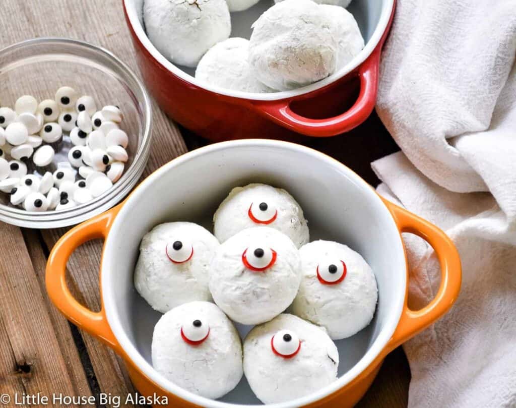 A bowl of cookies with eyeballs in it.