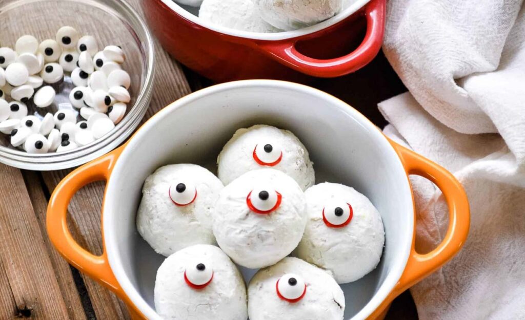 A bowl of cookies with eyeballs in it.