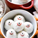 A bowl of cookies with eyeballs in it.