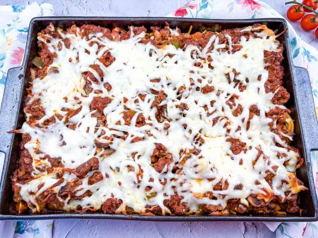 Spaghetti with meat and cheese in a baking dish.