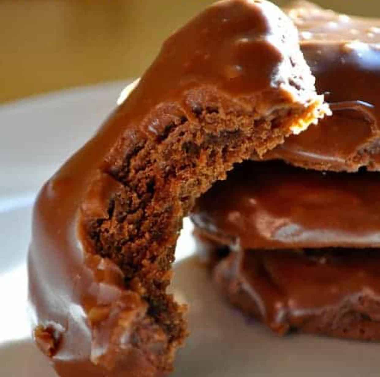 A stack of texas sheet cake cookies with a bite out of one cookie.