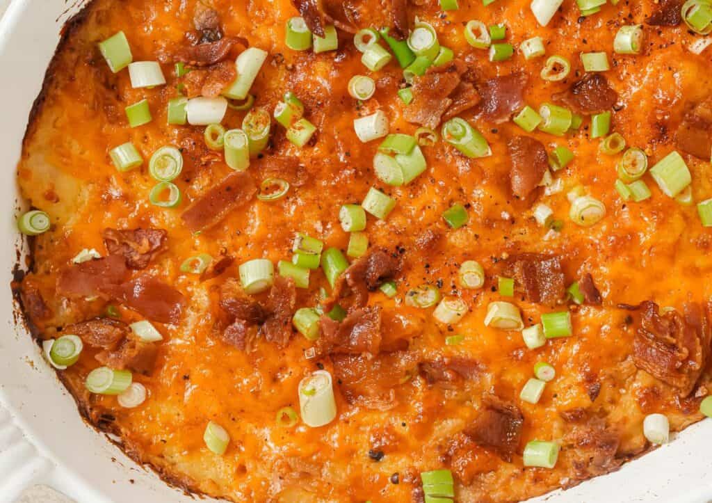 Twice baked potato casserole dish with cheese, bacon and green onions.
