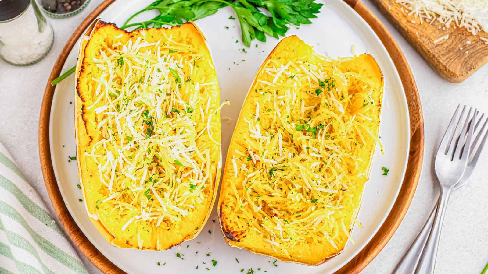 Air fryer spaghetti squash with parmesan on a white plate with parsley garnish.