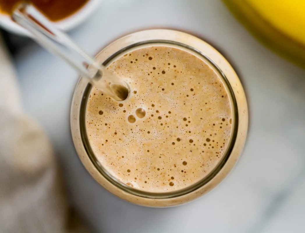 An overhead image of a Banana Almond Butter Smoothie in a glass.
