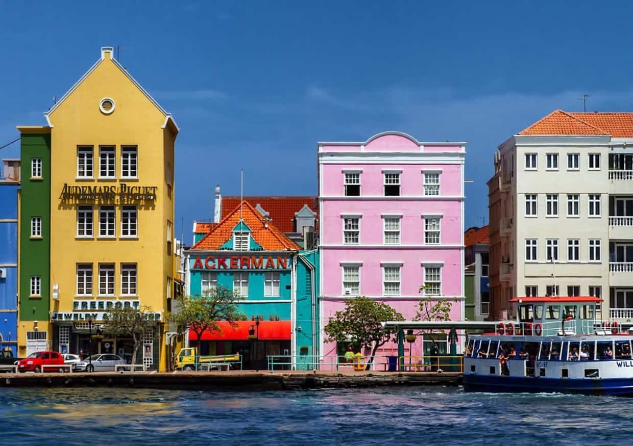 Colorful buildings on the water next to a boat.