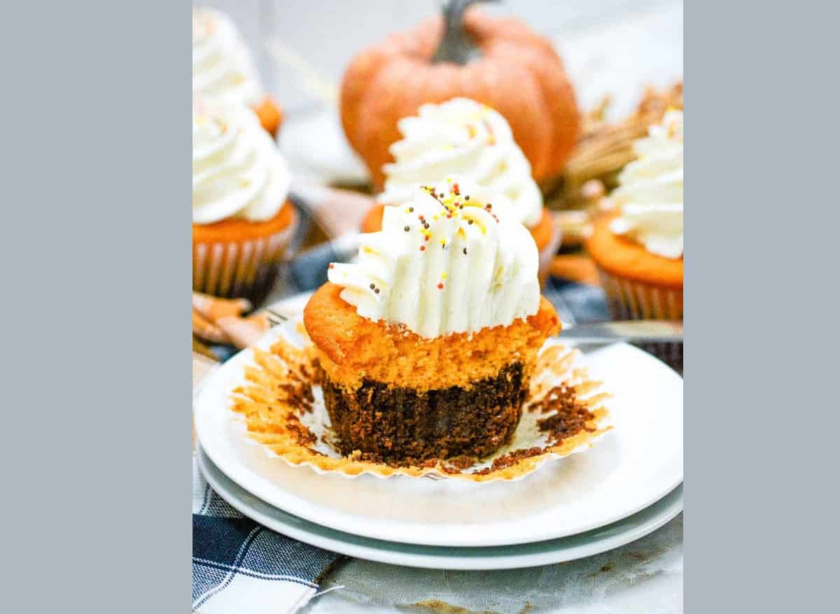 Fall brownie cupcakes with whipped cream on a plate.