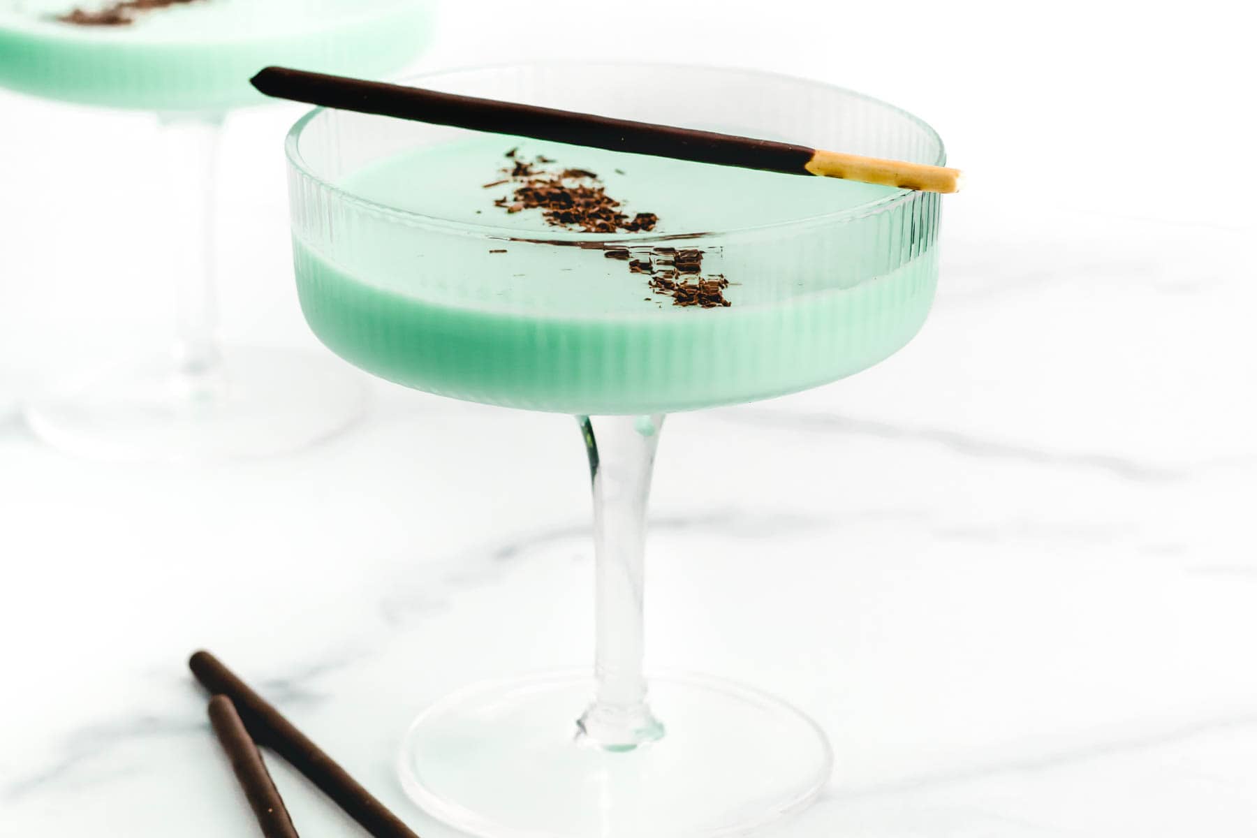 A cocktail with mint and chocolate garnishes in a martini glass.