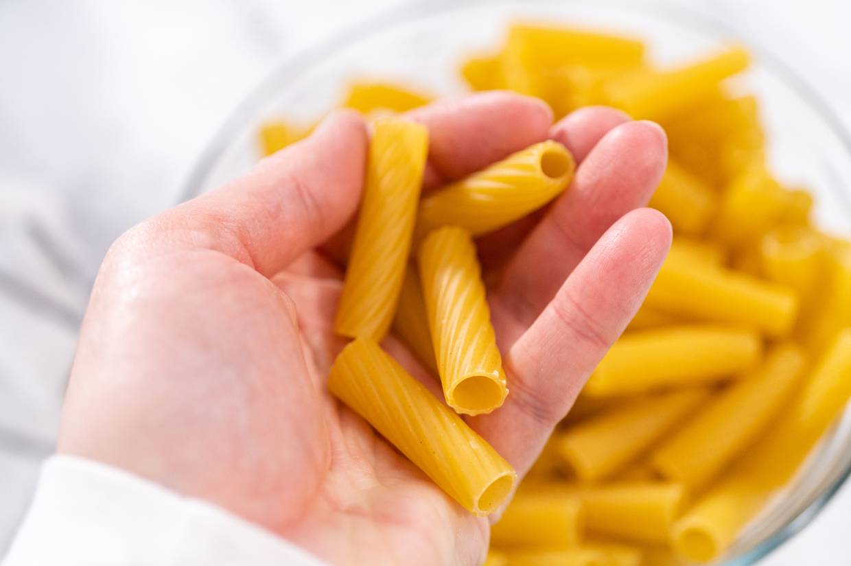 A person's hand holding low carb pasta.