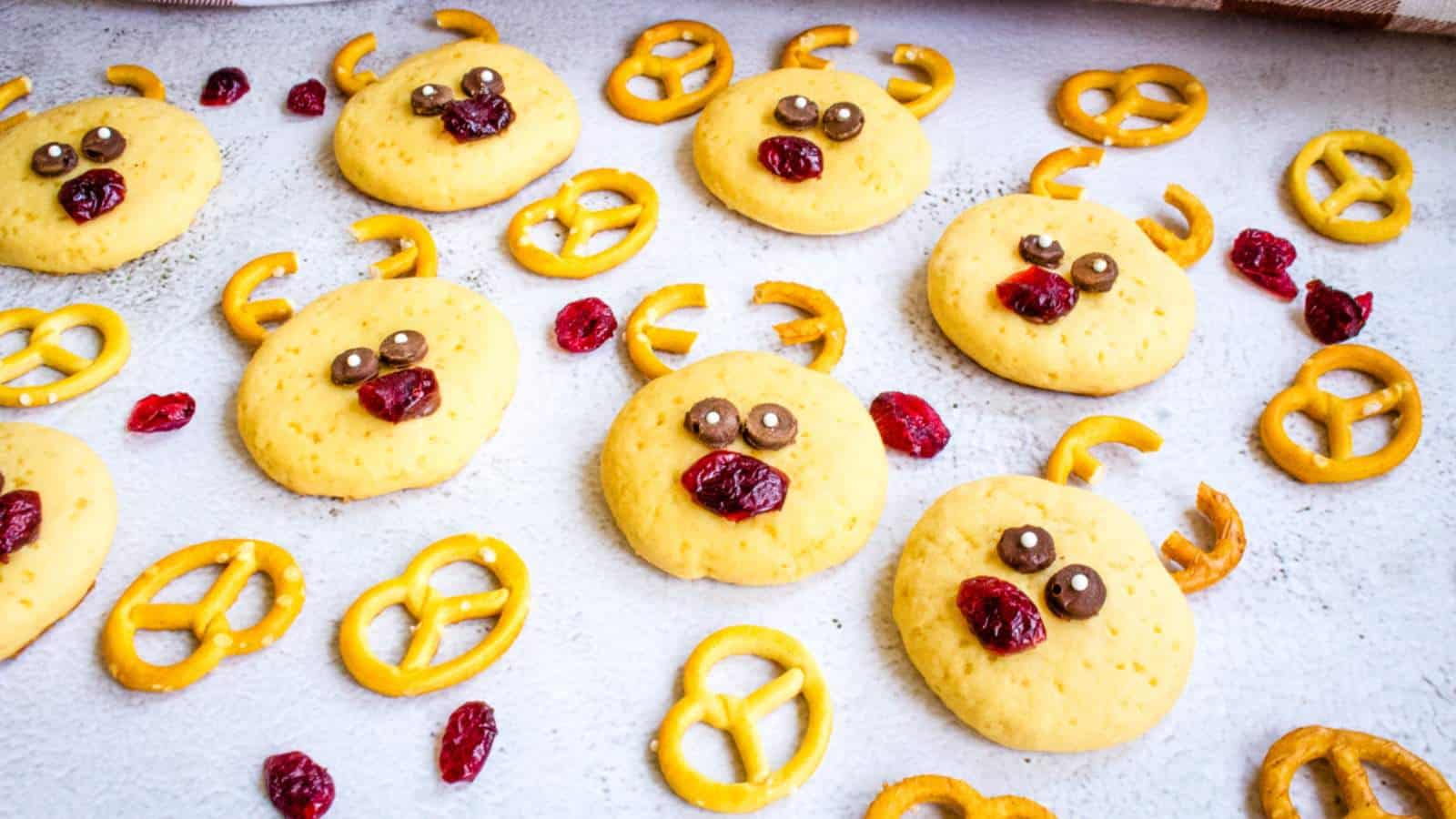 Peanut butter cookies with a face made of pretzels and dried cranberries to look like a reindeer.