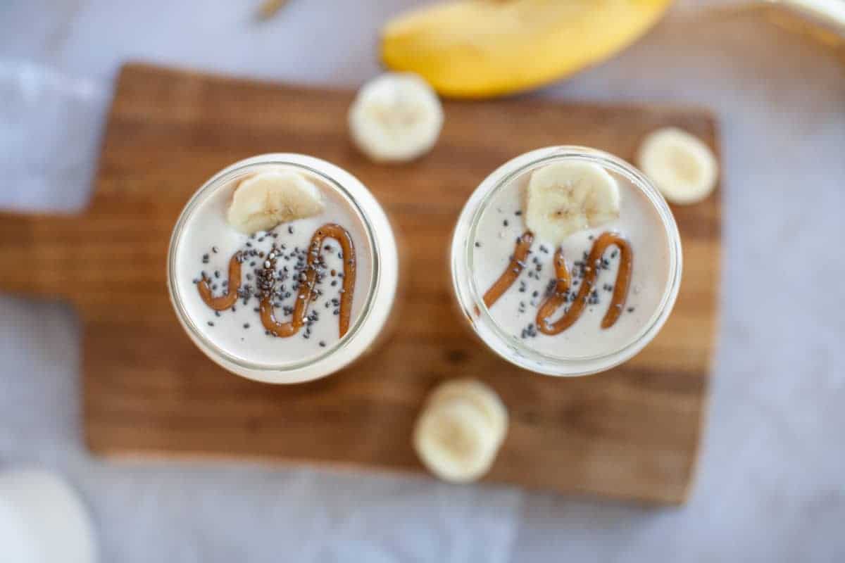 Two glasses of smoothie with bananas and chia seeds.
