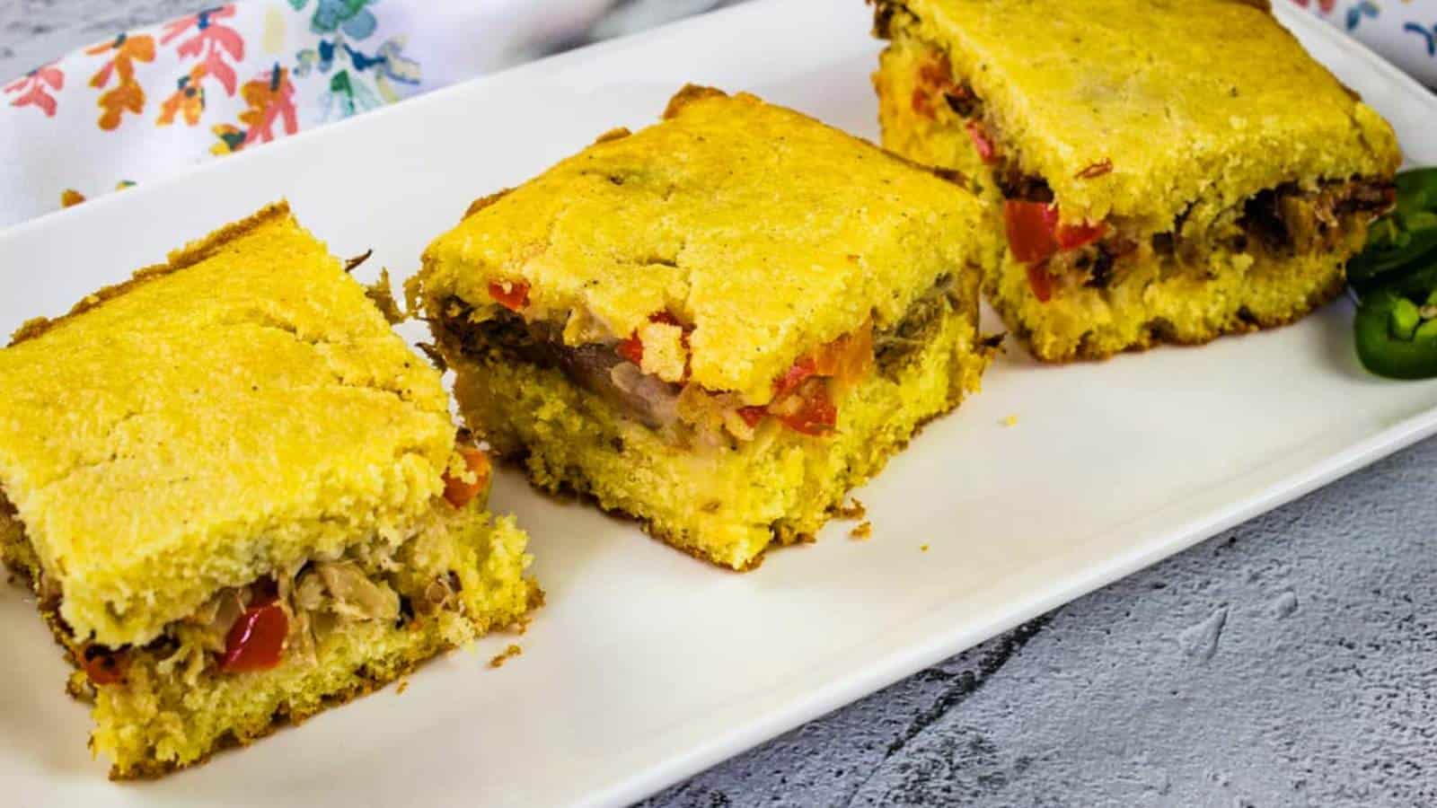 Three pieces of pulled pork stuffed cornbread on a white plate.