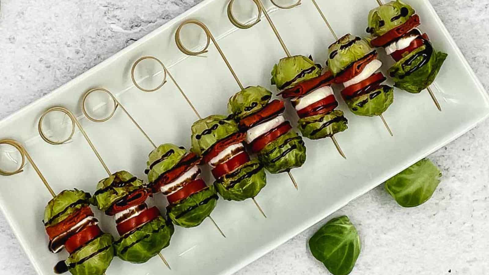 Brussels sprout skewers on a white plate.