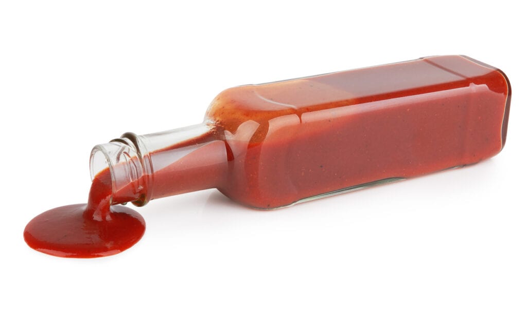A bottle of ketchup and chamoy on a white background.