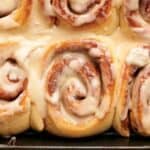 Cinnamon rolls in a pan with icing.