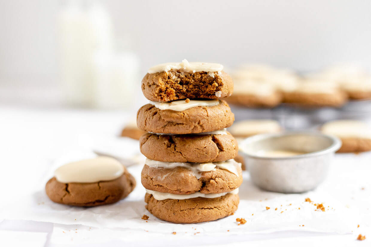 A stack of Iced Molasses Cookies with a bite taken out of them, perfect for winter gatherings or cozy dinners.