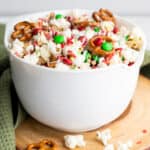 Christmas popcorn in a white bowl with pretzels.