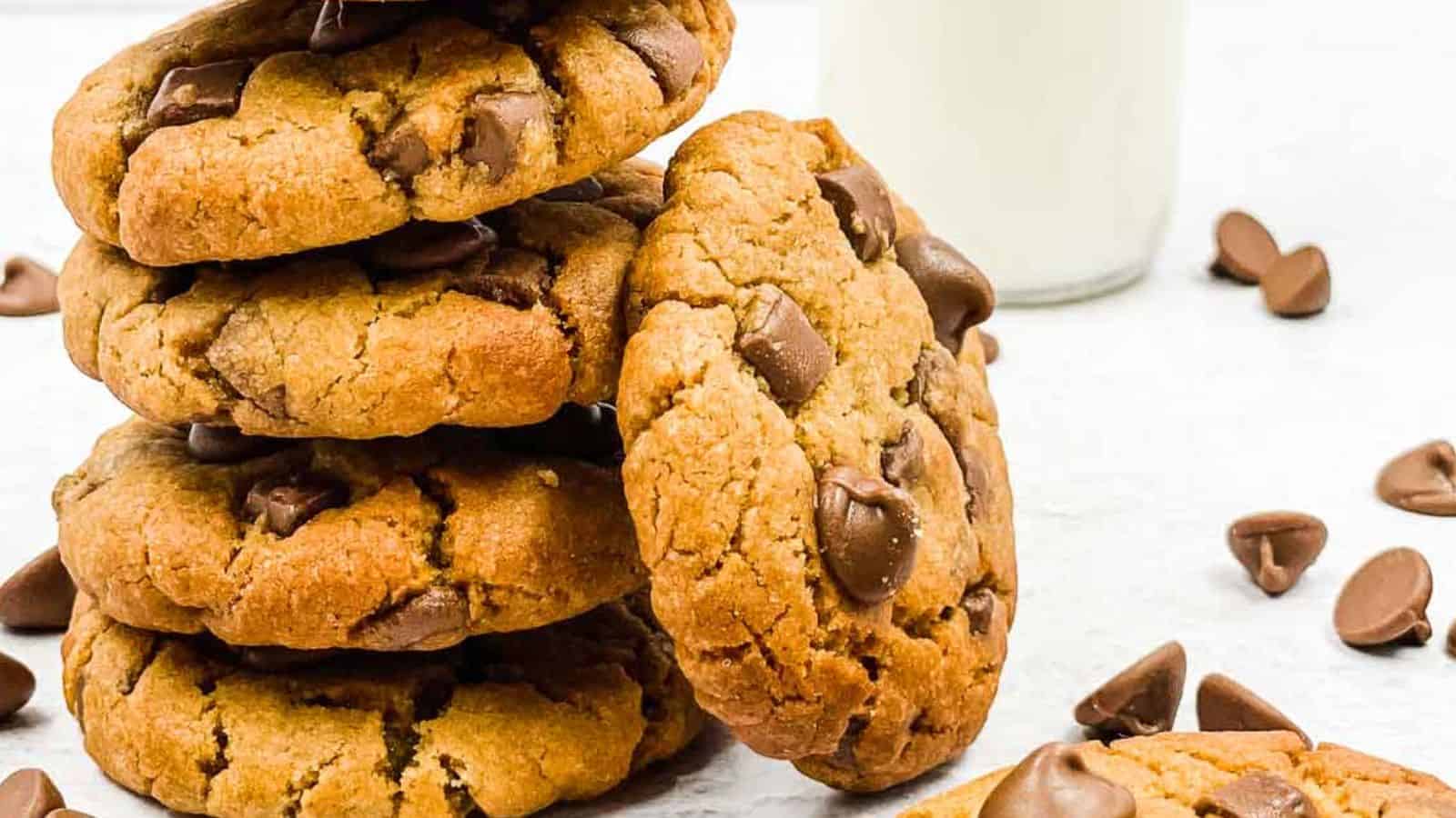 A stack of chocolate chip cookies with a glass of milk.
