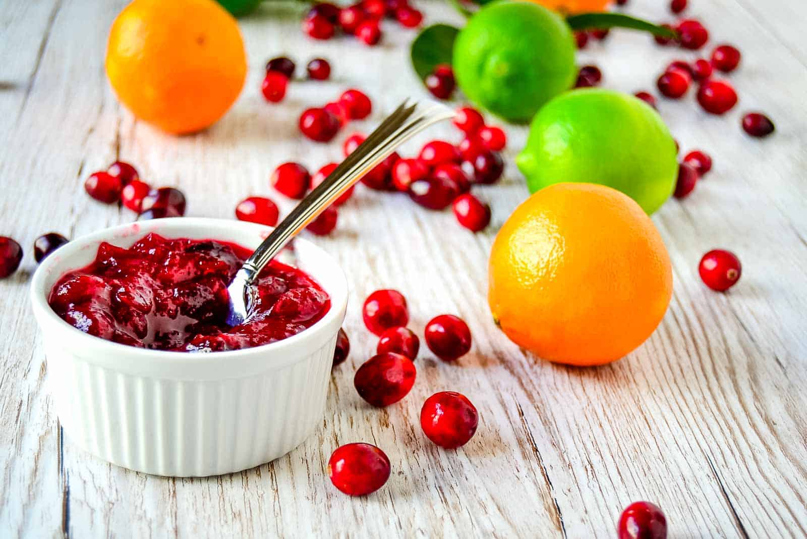A bowl of cranberry sauce with cranberries, oranges and lemons.