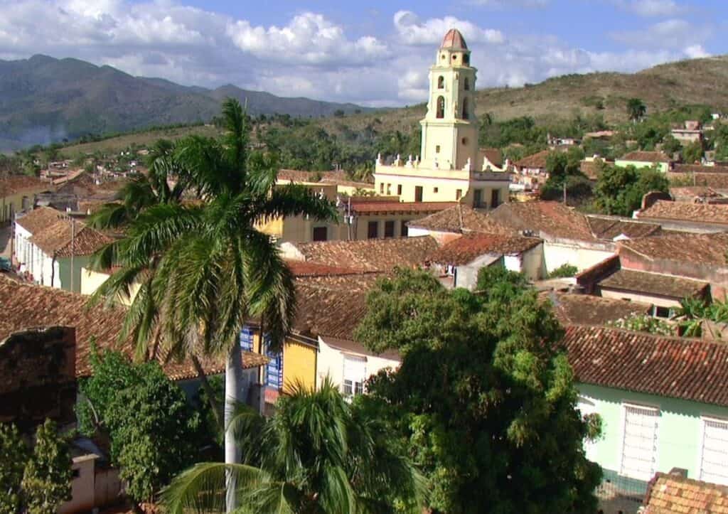 An aerial view of a town with palm trees and a clock tower.