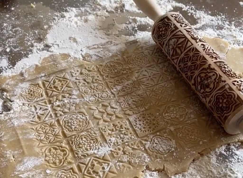 An embossed wooden rolling pin with a pattern on it.
