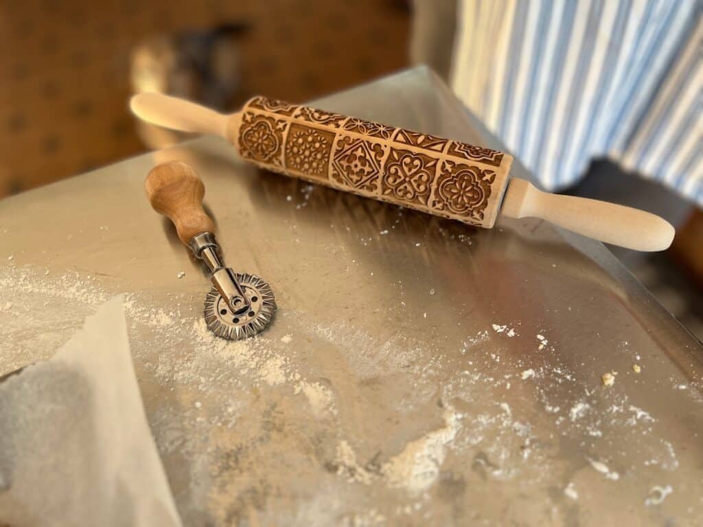 An embossed wooden rolling pin on a table.