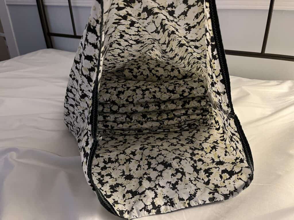 A floral bag sitting on top of a bed.